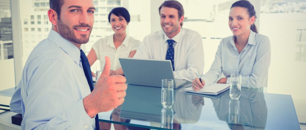 Executive gesturing thumbs up with recruiters during interview